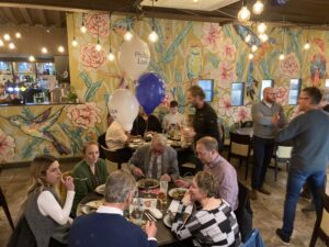 People at the quiz sat eating, chatting and having fun.